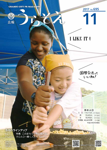 表紙写真、石臼を回す研修員と子どもの様子